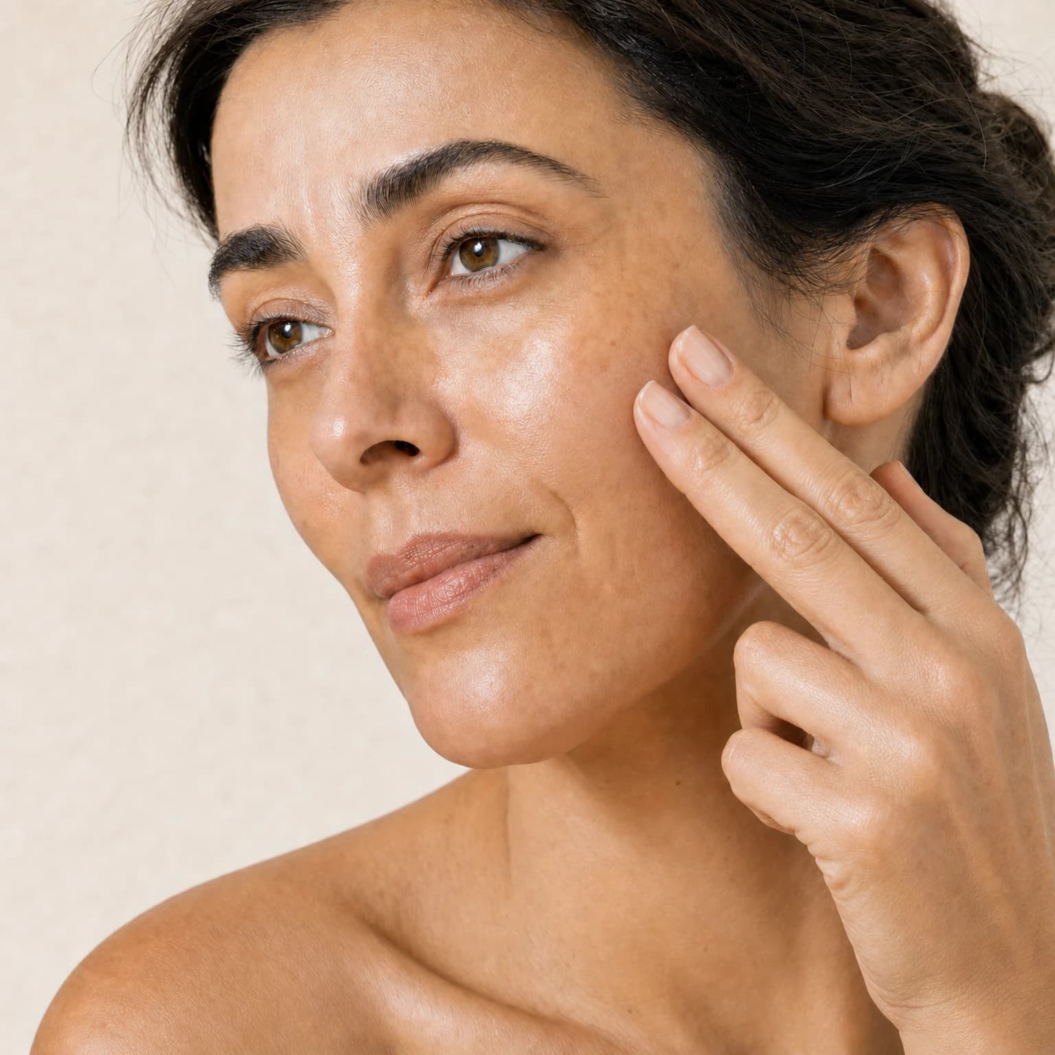 Fingertips gently blending balm onto the cheek